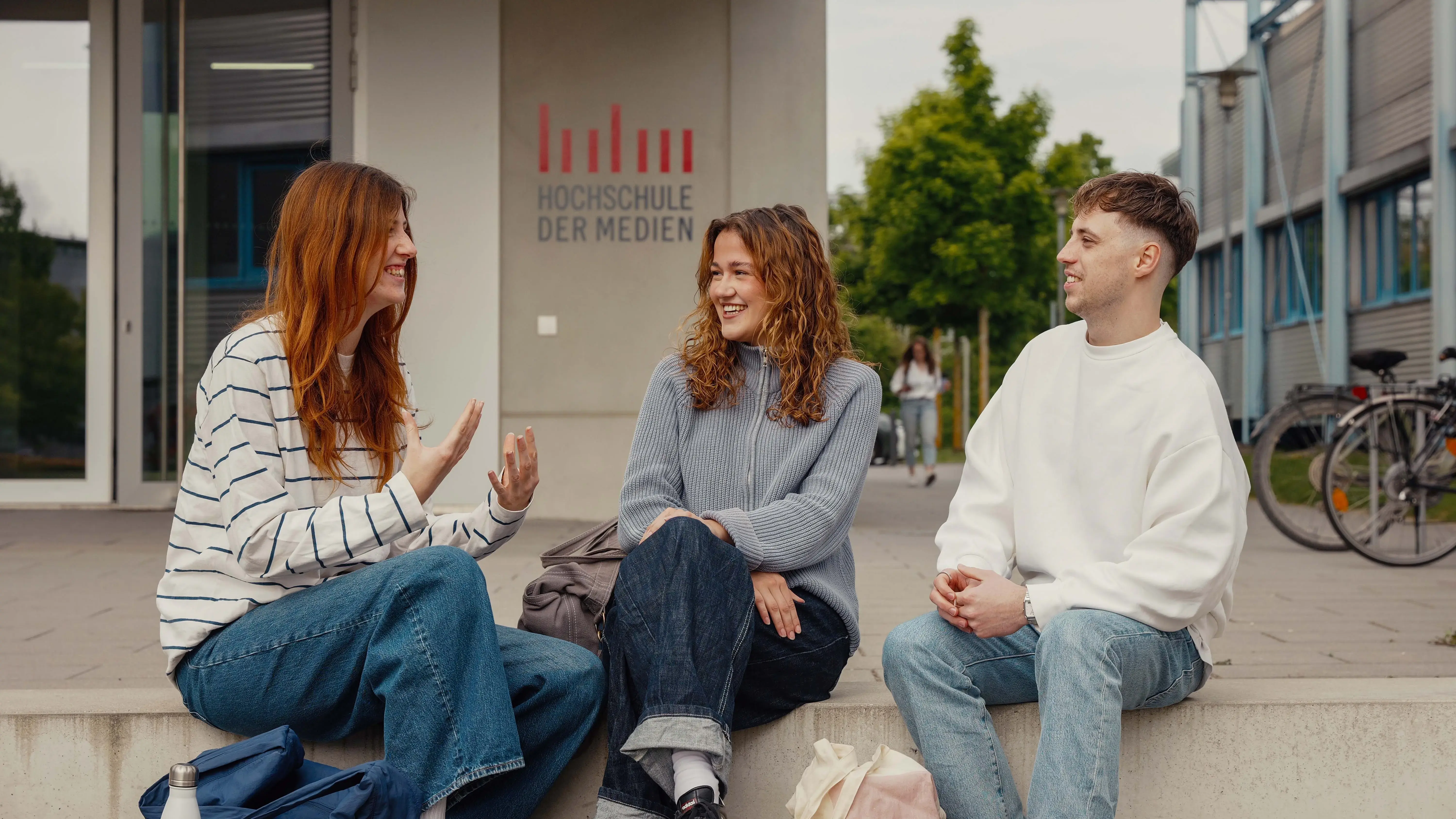 Studierende unterhalten sich vor der Hochschule der Medien.