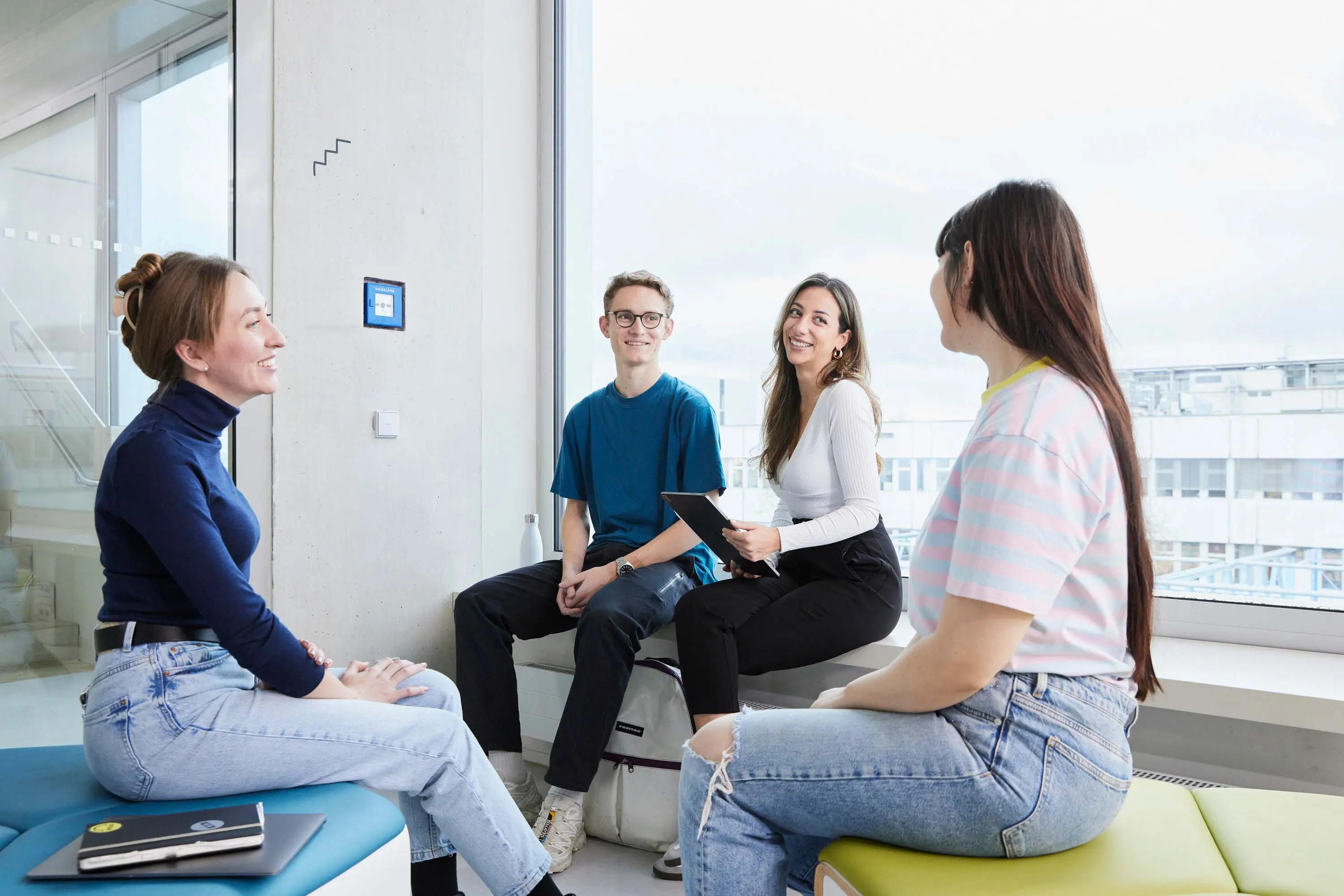 Studierende besprechen sich in einer kleinen Gruppe.