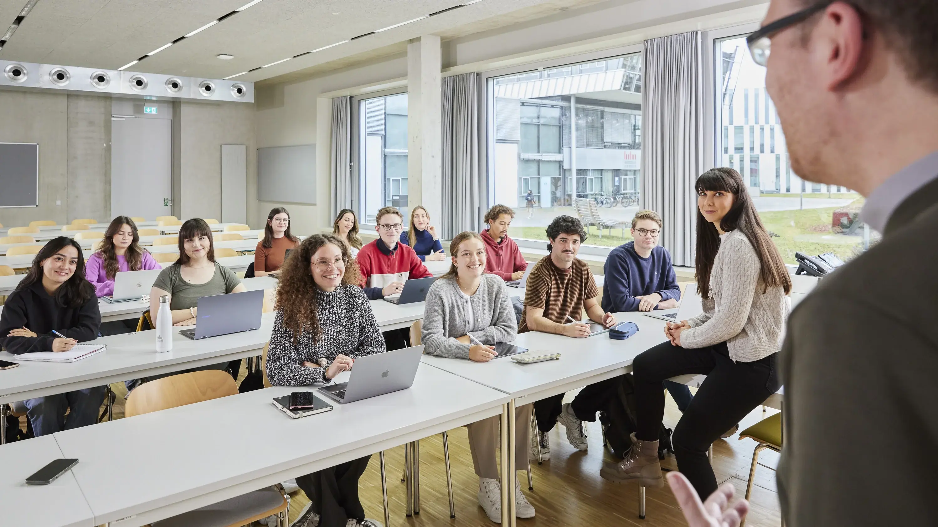 Ein Professor mit seinen Studierenden in der Vorlesung.