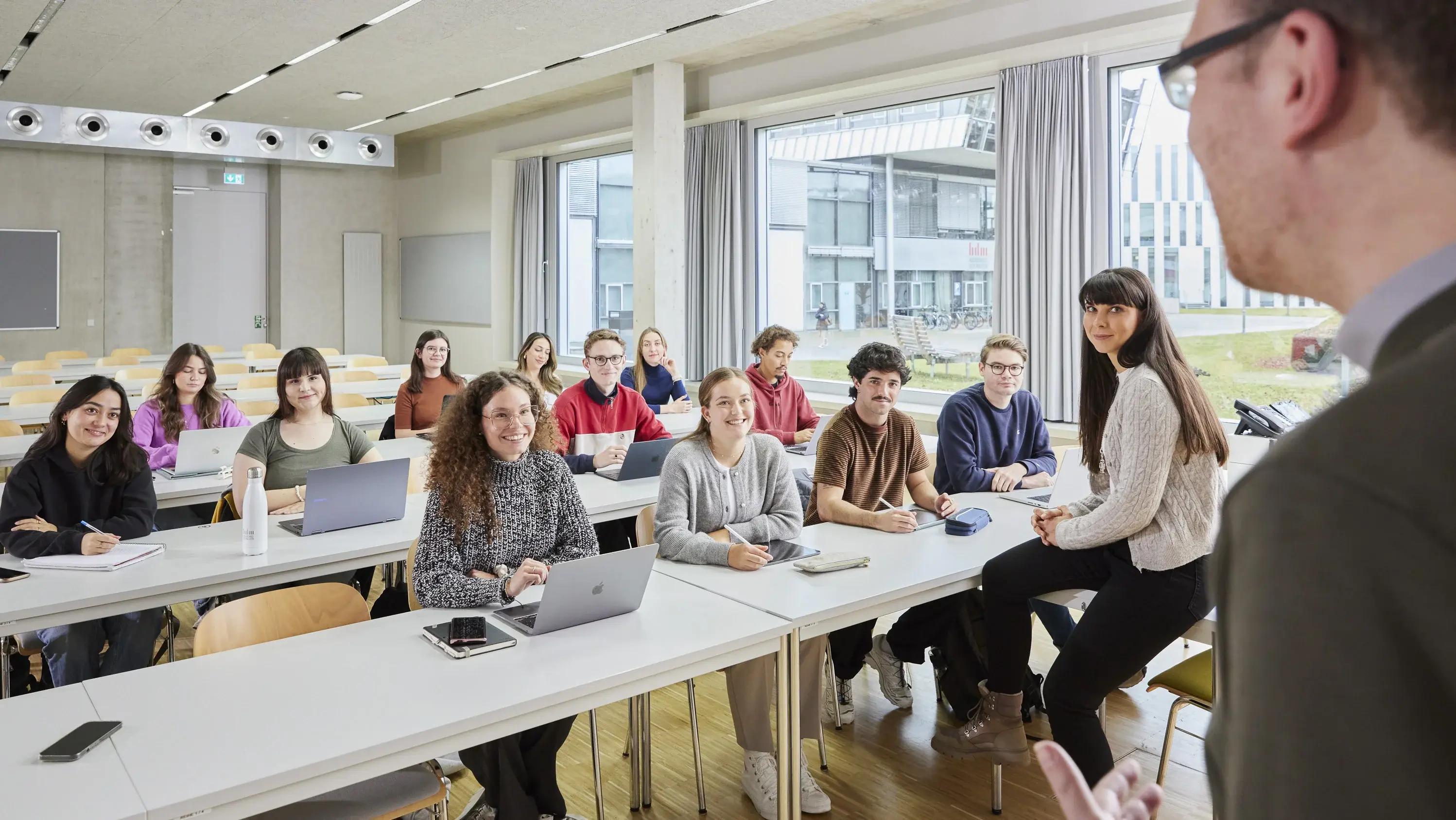 Ein Professor mit seinen Studierenden in der Vorlesung.