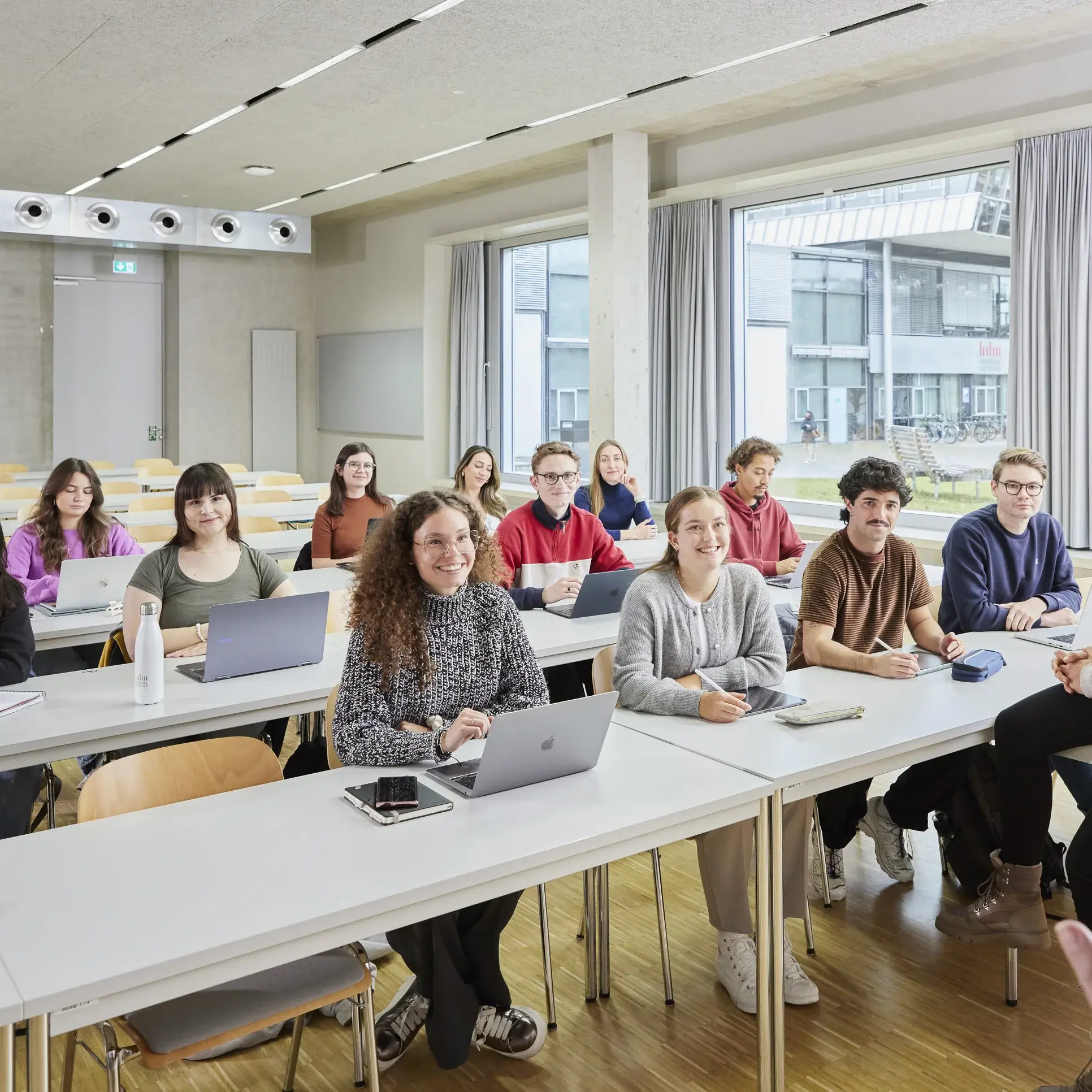 Ein Professor mit seinen Studierenden in der Vorlesung.